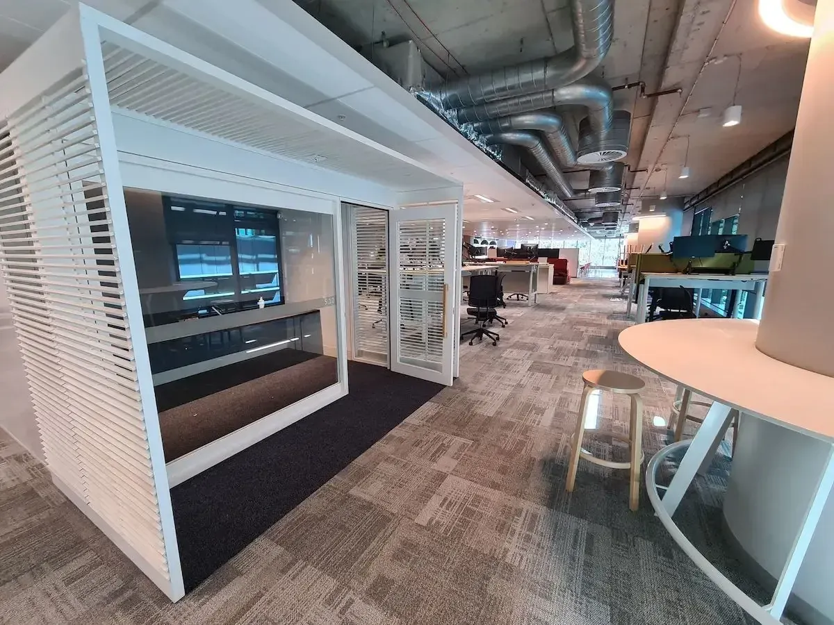 Open-plan office with carpet tile and a meeting pod, installed by Briz Floors