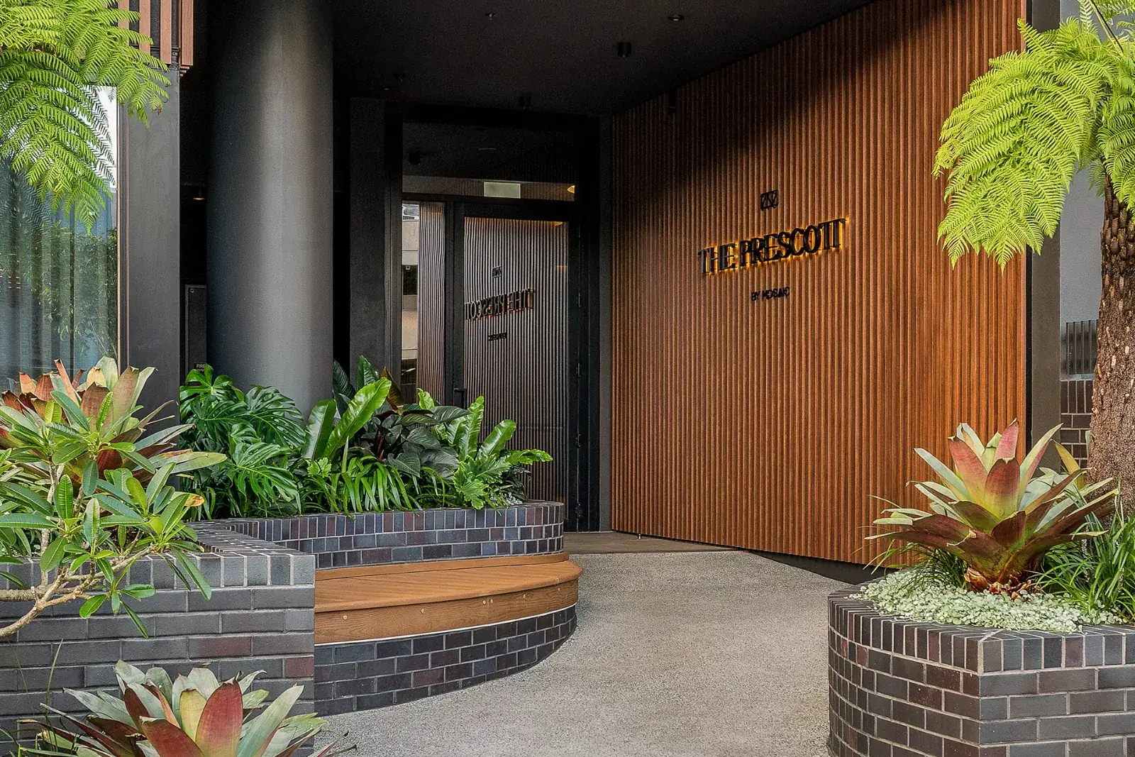 The Prescott entrance with timber battens and garden beds